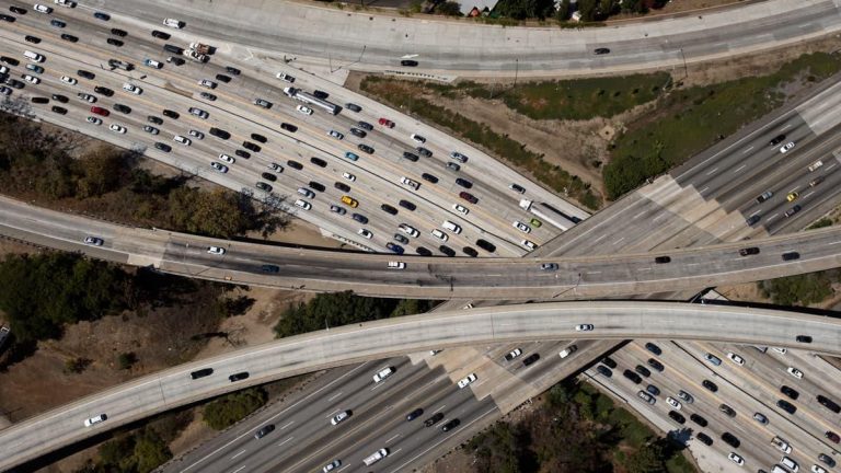 Aerial view of a busy multi-level highway interchange with many vehicles