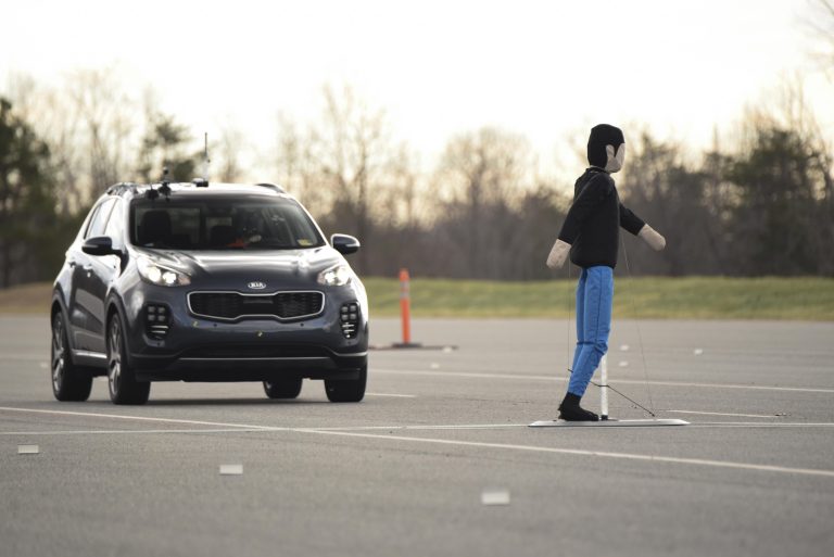 SUV approaches pedestrian braking test dummy