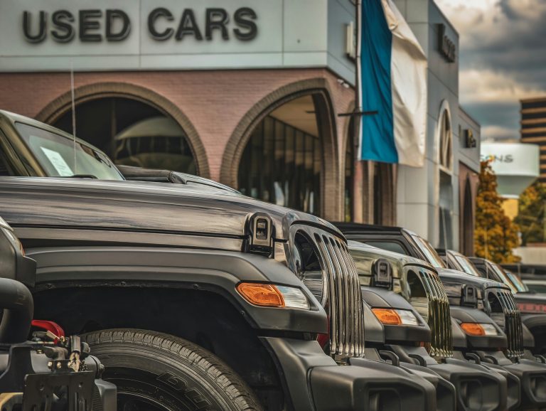 Mnay cars are standing in front of a used car dealership