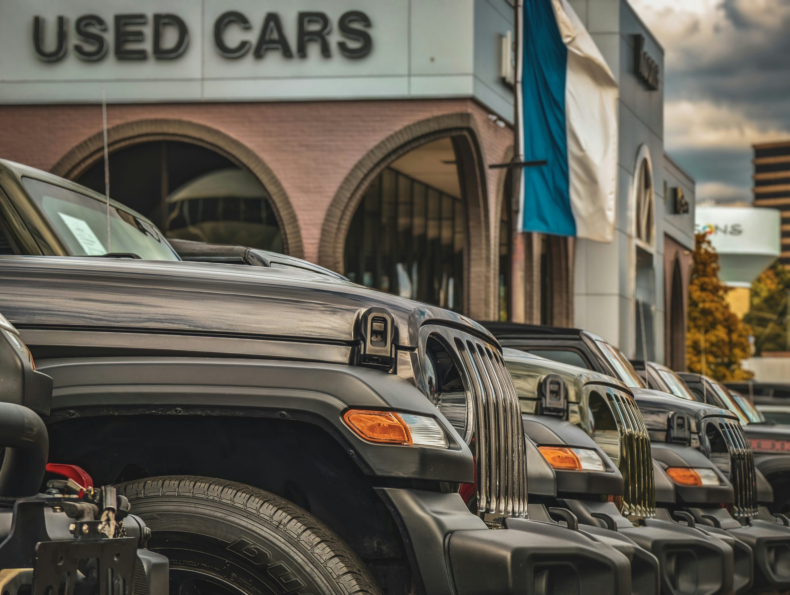Mnay cars are standing in front of a used car dealership