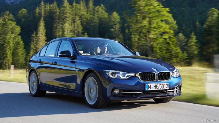 2016 BMW 3 Series sedan cruising along a forest-lined road, highlighting its sporty design