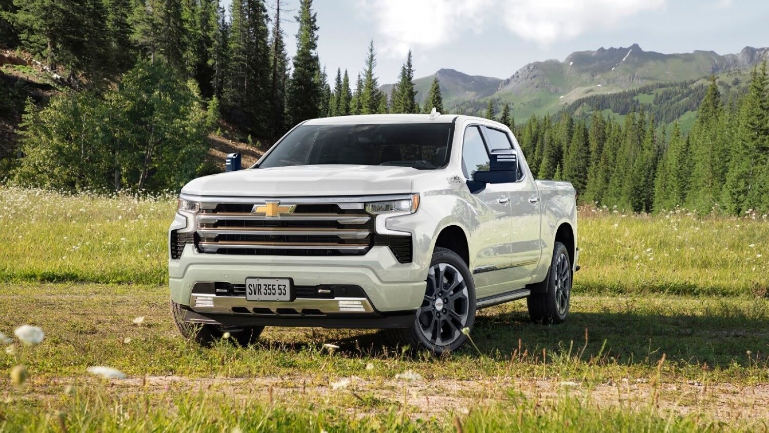 2024 Chevrolet Silverado 1500 High Country parked in a mountain meadow surrounded by pine forests