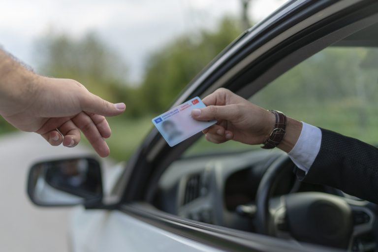 Policeman gives driver a traffic ticket.