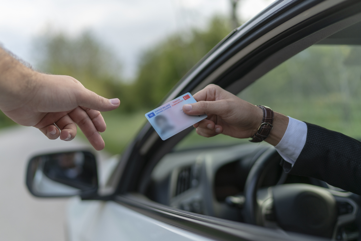 Policeman gives driver a traffic ticket.