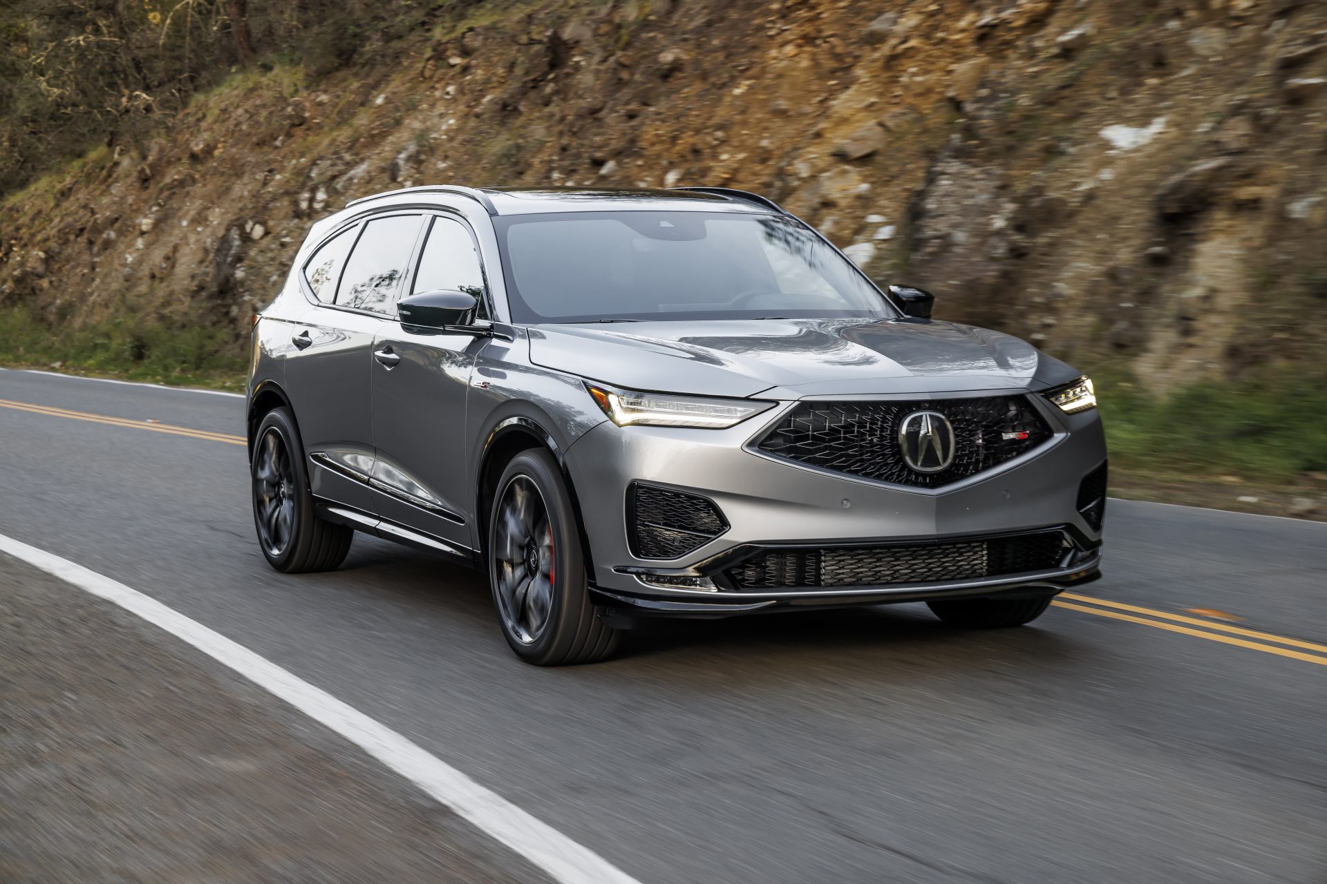 Acura MDX Type S drives along a winding mountain road, showcasing its premium SUV styling