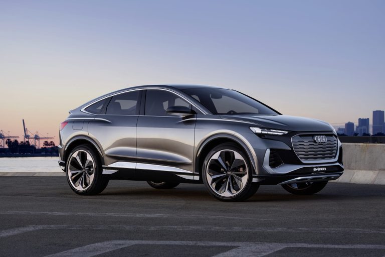 Audi Q4 e-tron parked beside the waterfront with a city skyline in background