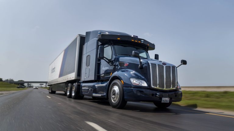 Aurora Innovation's autonomous semi-truck hauling a freight trailer on a highway, demonstrating driverless trucking technology
