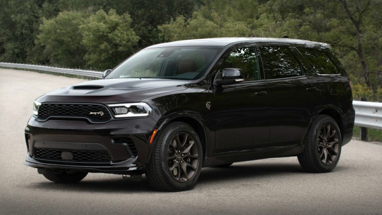 Black Dodge Durango SRT Hellcat parked roadside, showcasing its aggressive styling, hood scoop, and sporty wheels