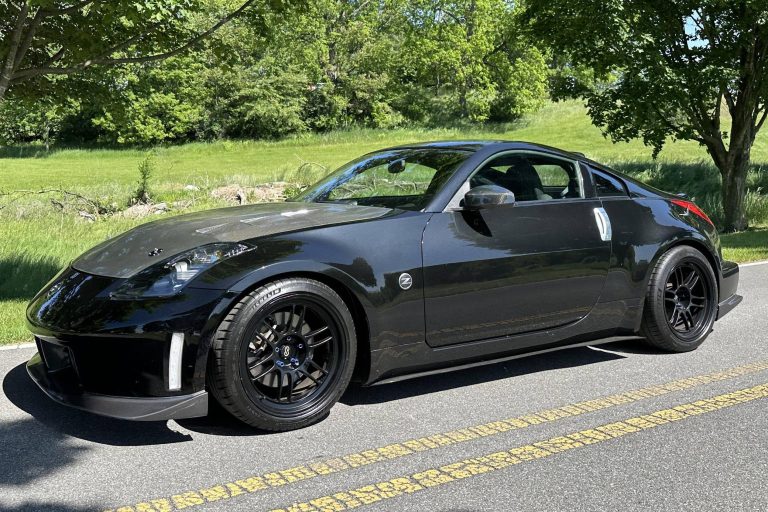 Black Nissan 350Z parked on a scenic road, highlighting its sporty design
