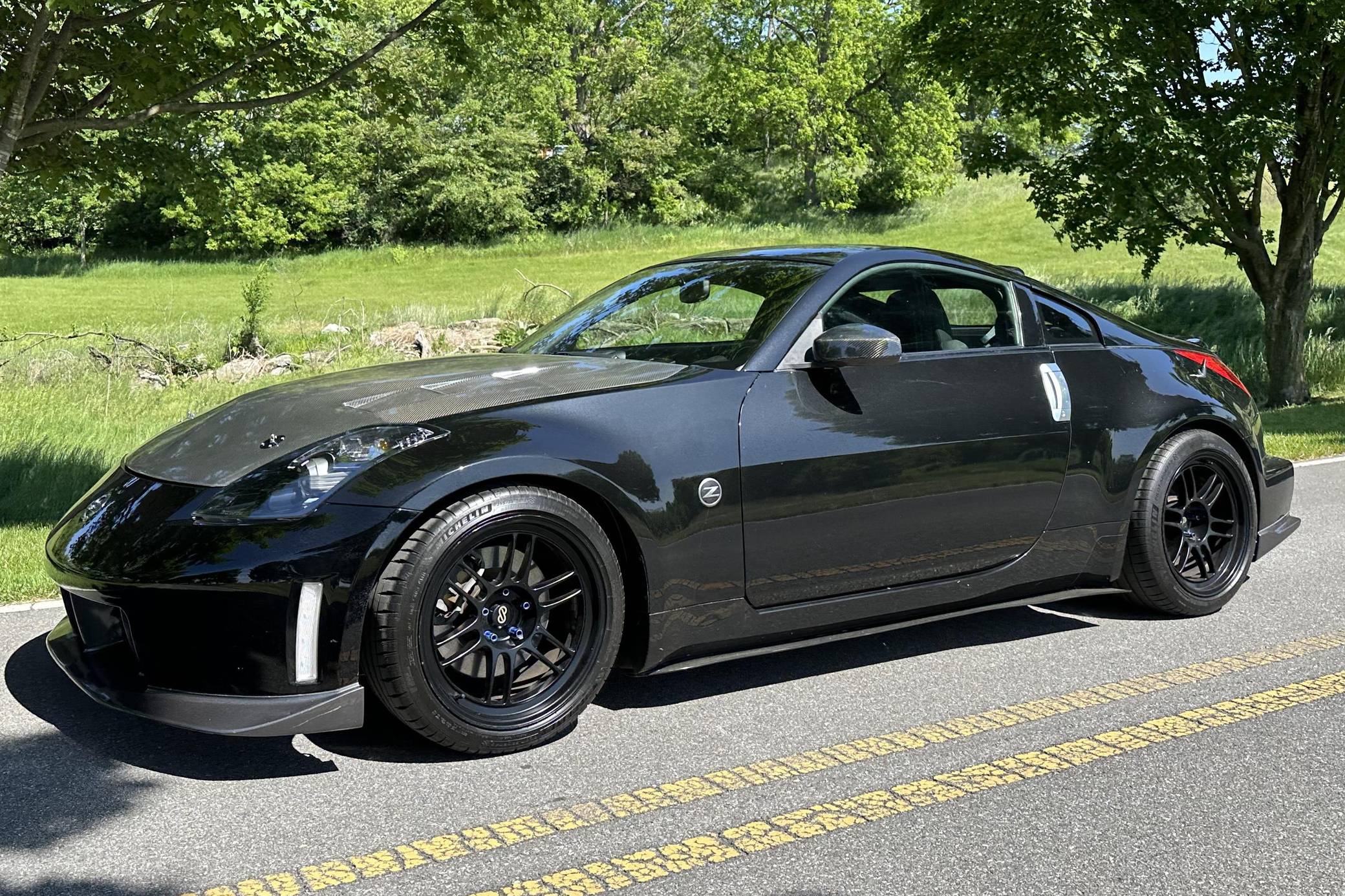 Black Nissan 350Z parked on a scenic road, highlighting its sporty design