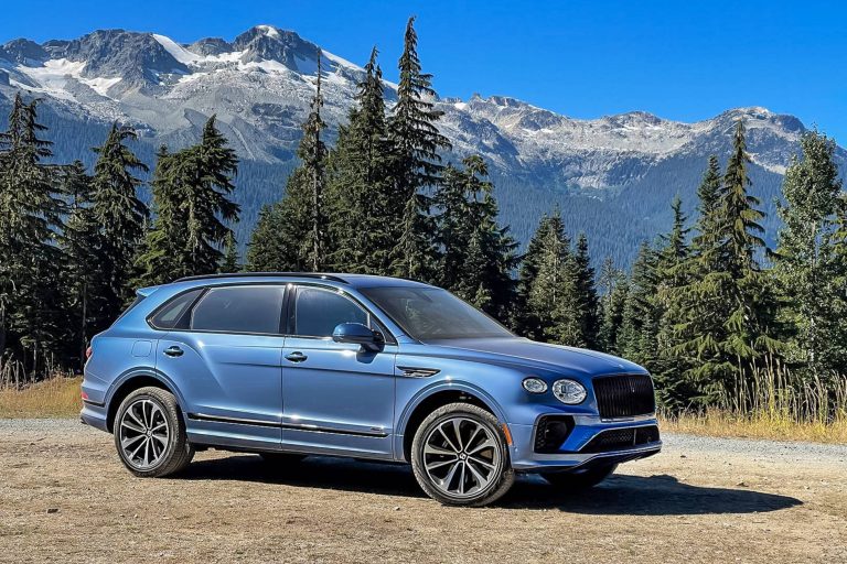 Blue Bentley Bentayga parked against a stunning alpine backdrop, highlighting its luxurious design and elegant styling