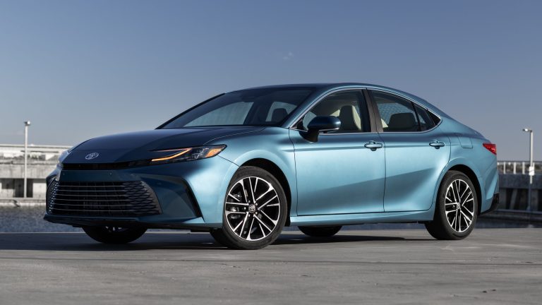 Blue Toyota Camry sedan parked on a rooftop, showcasing its sleek styling and alloy wheels
