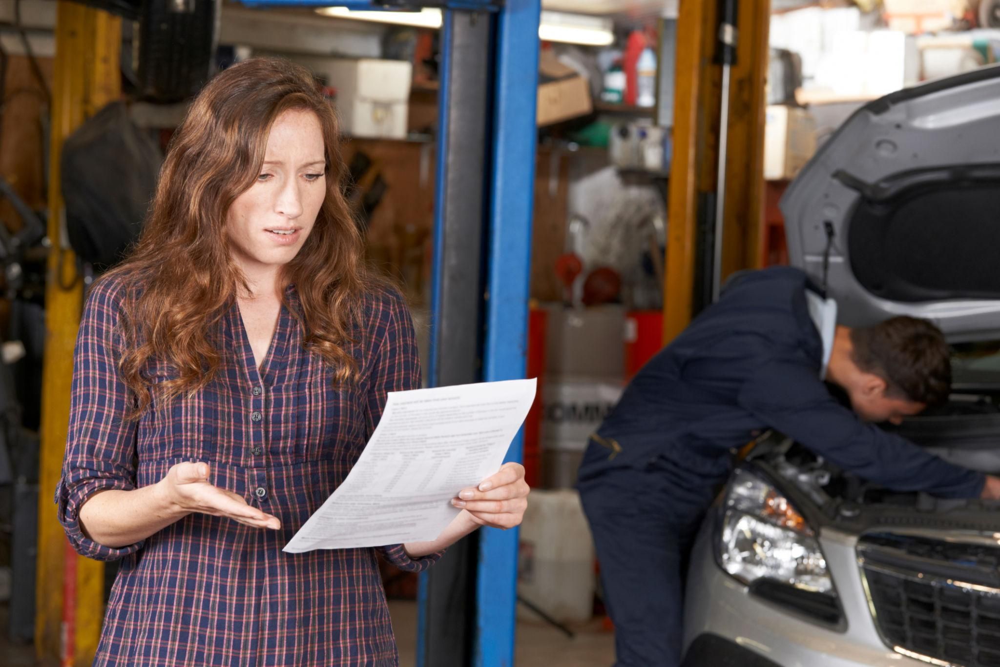 Woman reviewing a car repair bill.