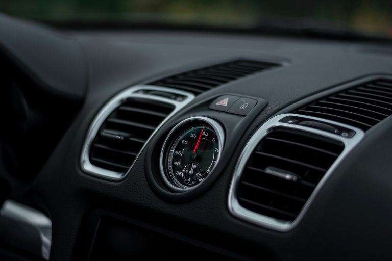 An interior of a car is shown, we see the vent pipes of an air conditioning system