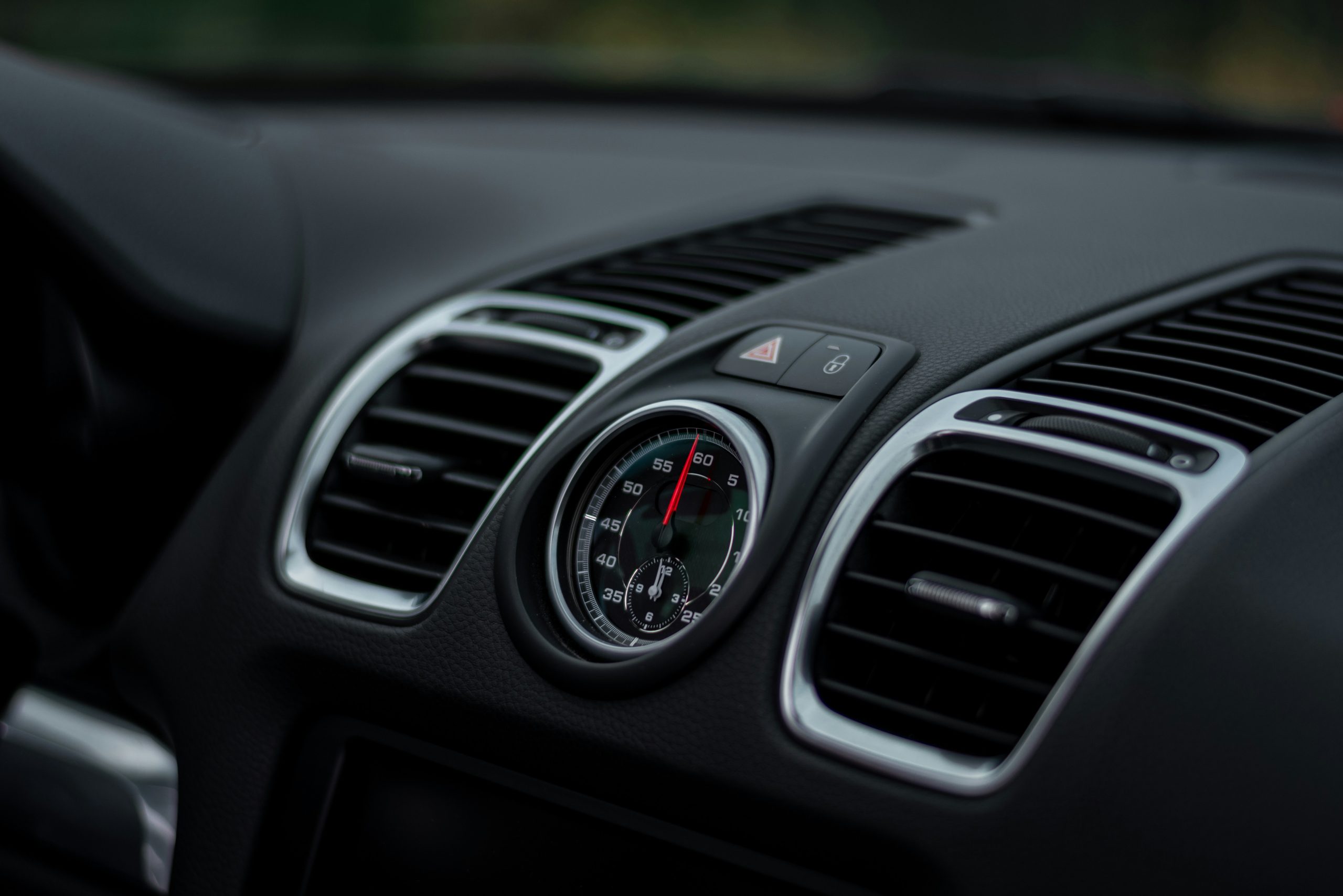 An interior of a car is shown, we see the vent pipes of an air conditioning system
