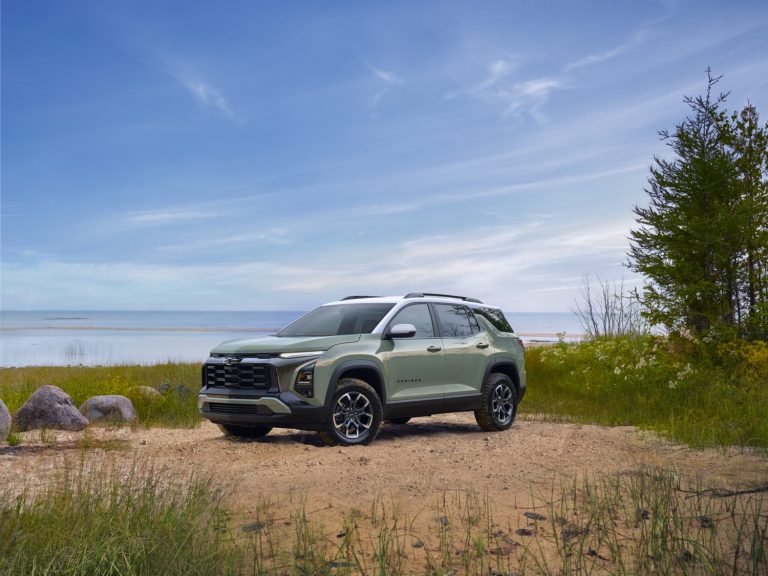 Chevrolet Equinox parked beside a lakeshore with trees and mountains nearby