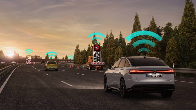 Connected Volkswagen electric car approaches a smart highway speed sign with wireless communication signals