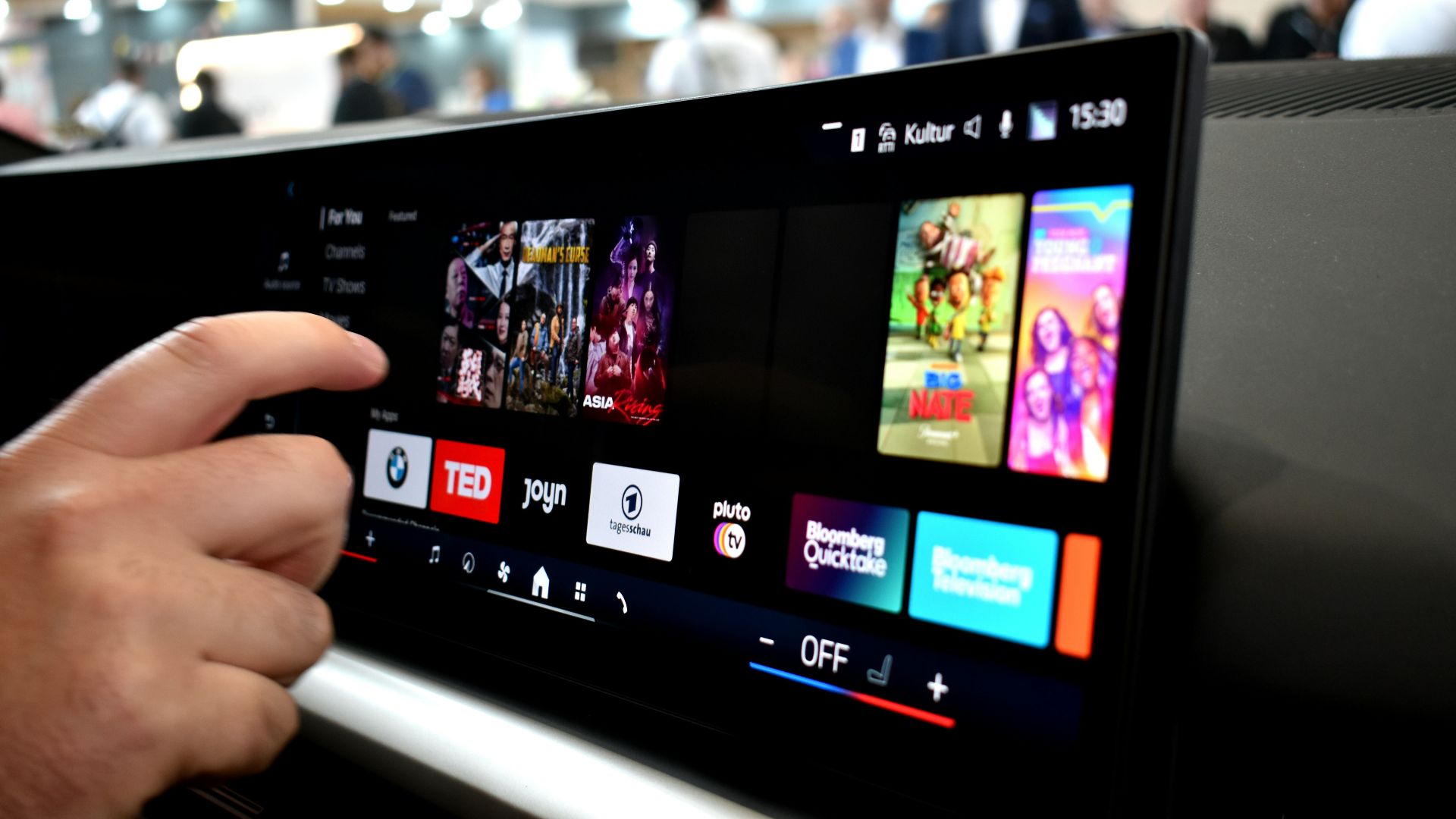 Driver interacting with a vehicle touchscreen displaying entertainment and connected media apps