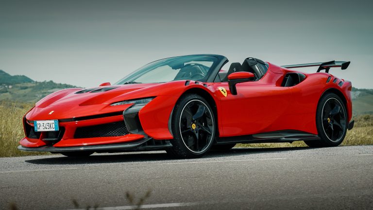 Ferrari SF90 Spider parked on a scenic mountain road with an open-air cockpit