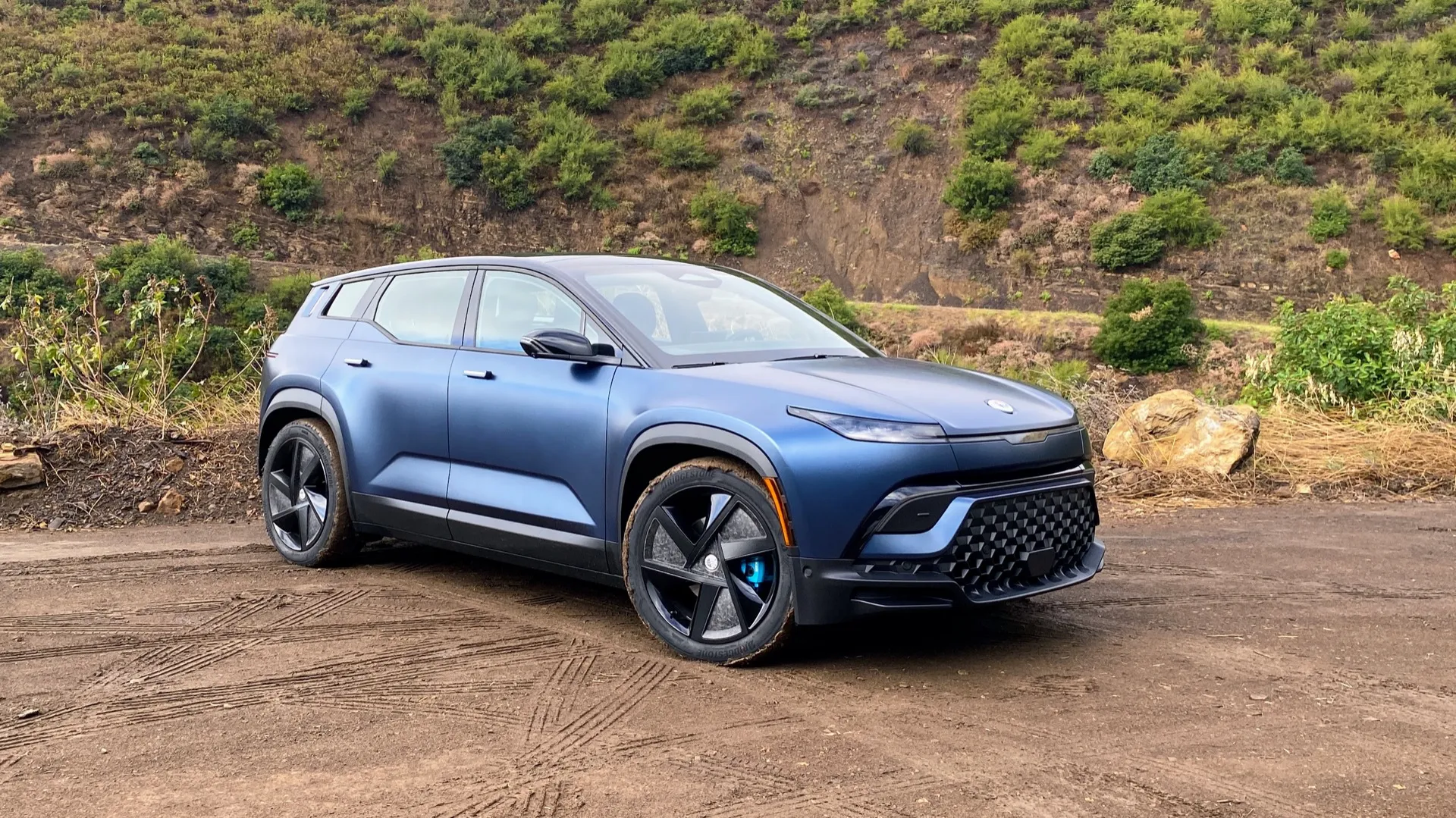 A fisker Ocean is standing with muddy tires