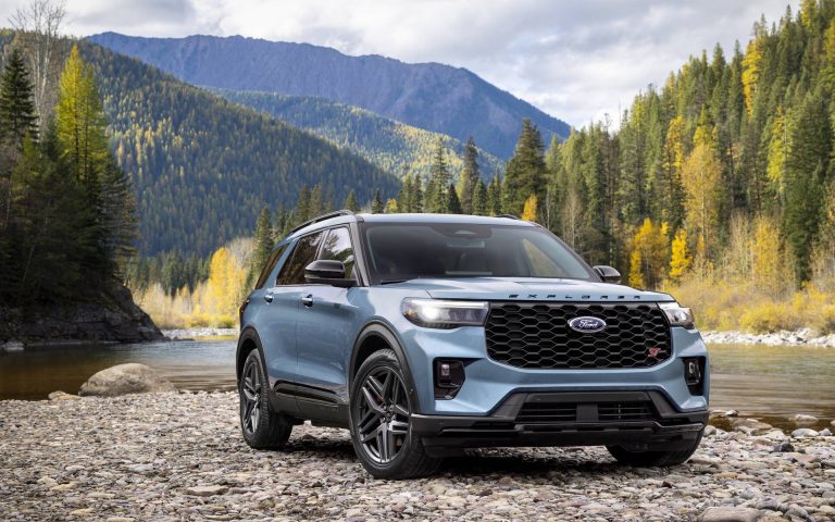 Ford Explorer ST parked beside a river with mountains and autumn forest surrounding it