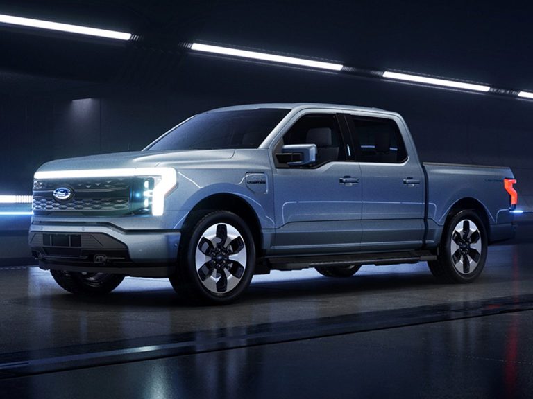 Ford Fathom electric pickup displayed in a futuristic studio, highlighting its illuminated front design and modern styling