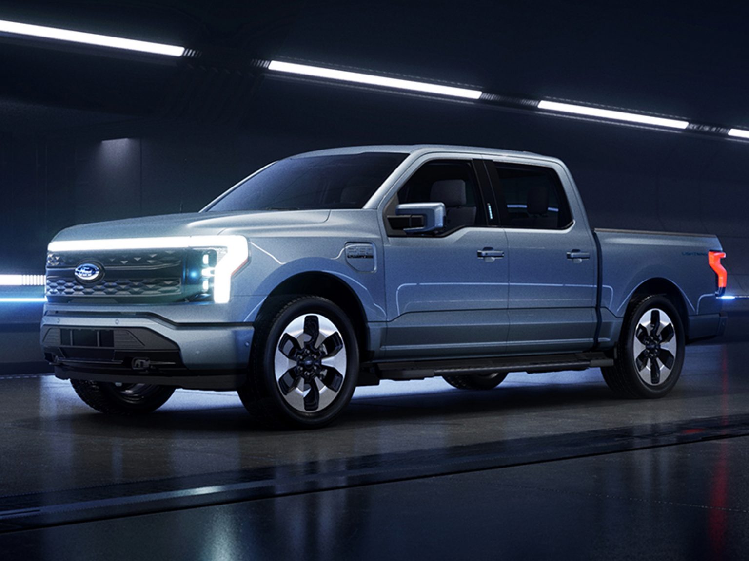 Ford Fathom electric pickup displayed in a futuristic studio, highlighting its illuminated front design and modern styling