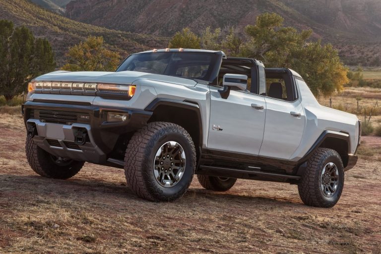 GMC Hummer EV drives through rugged mountain terrain, showcasing its off-road design