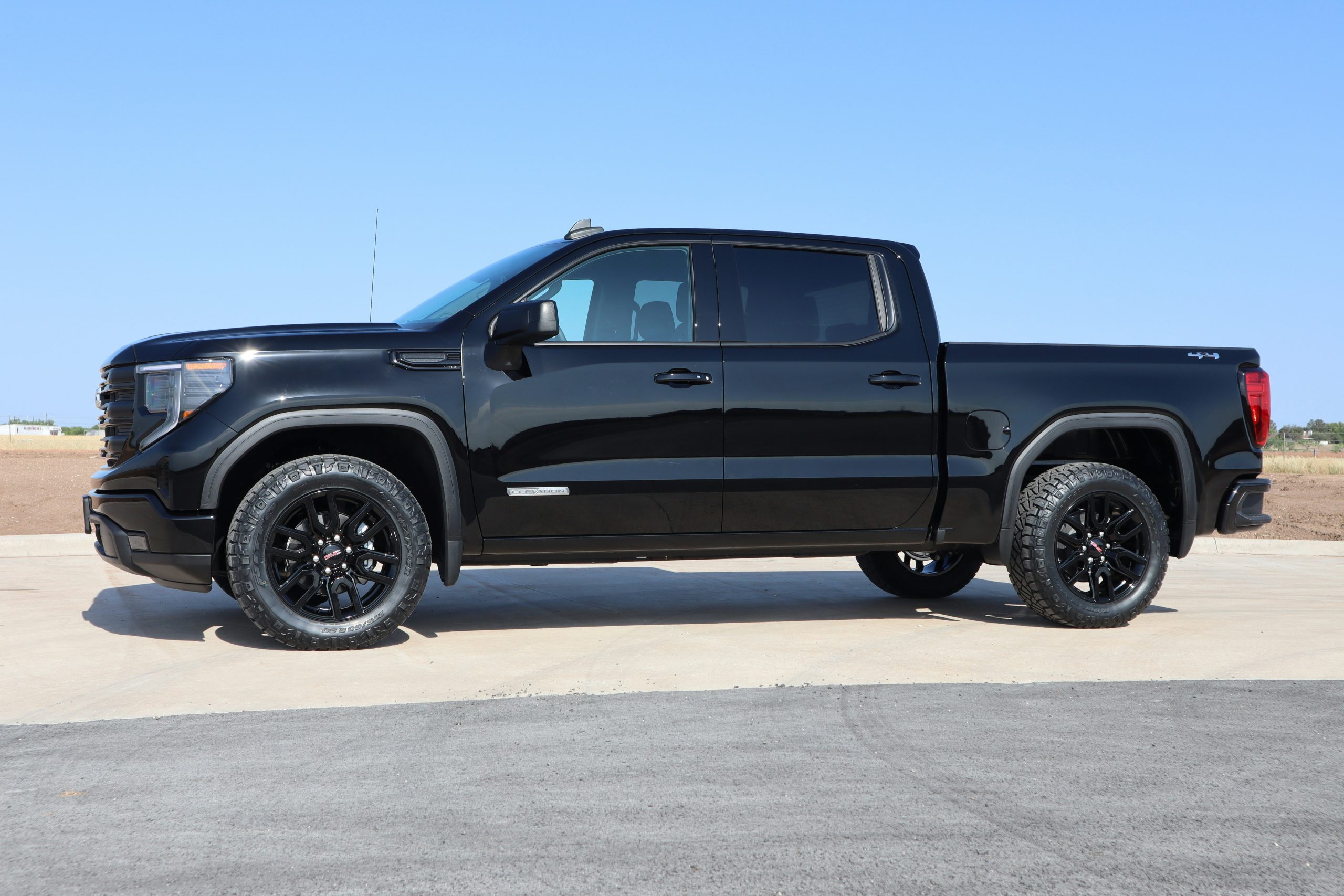 A GMC Sierra is standing on a concrete on a sunny day