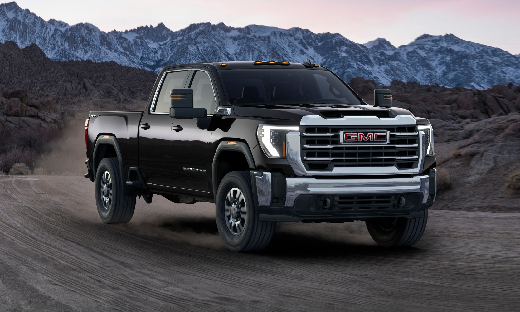 GMC Sierra 2500 drives along a rugged mountain trail, showcasing its heavy-duty capability and imposing design