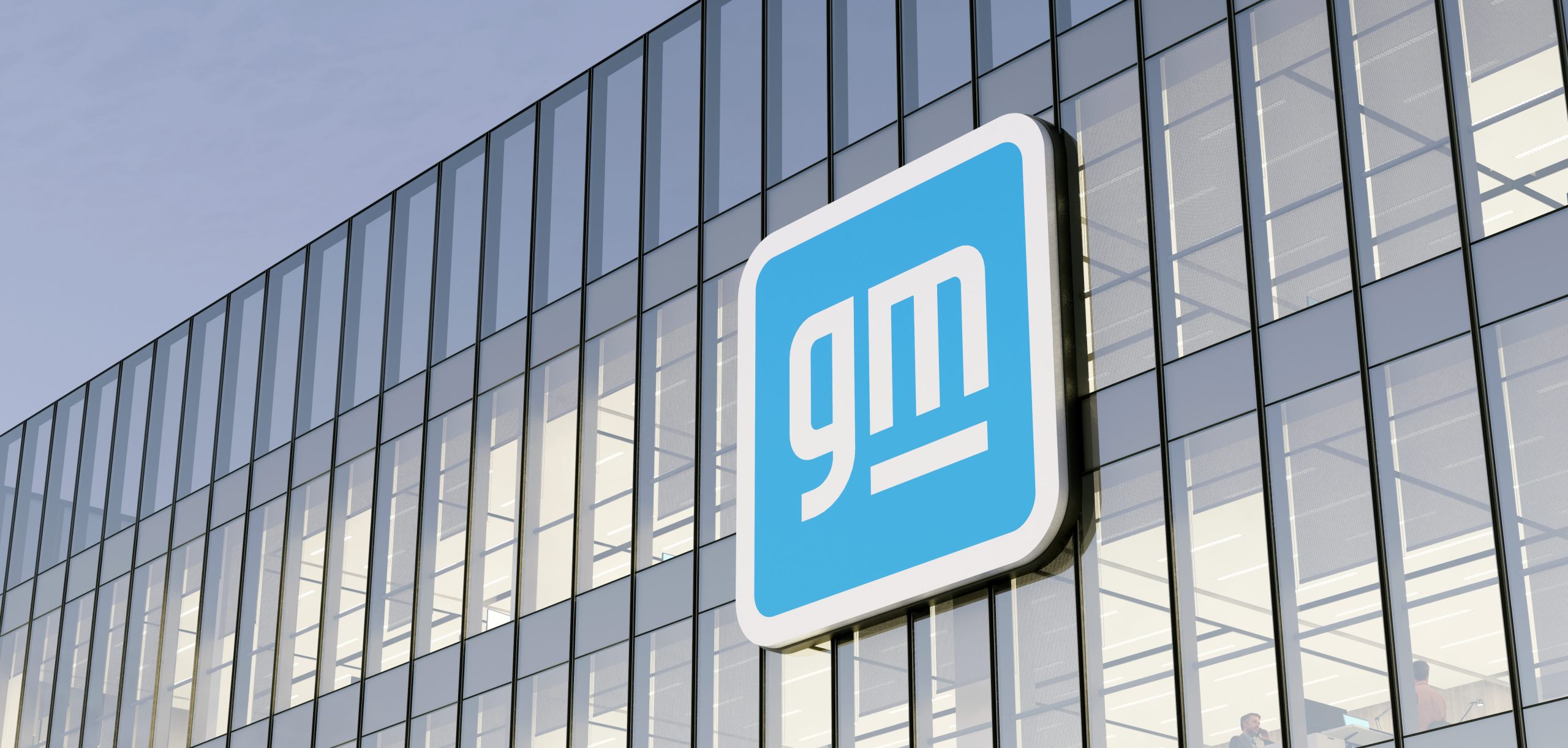 General Motors logo displayed on a modern glass office building facade