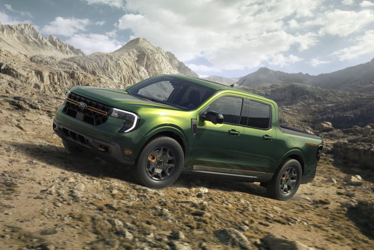 Green Ford Maverick Tremor pickup navigates rugged rocky terrain, showcasing its off-road capabilities