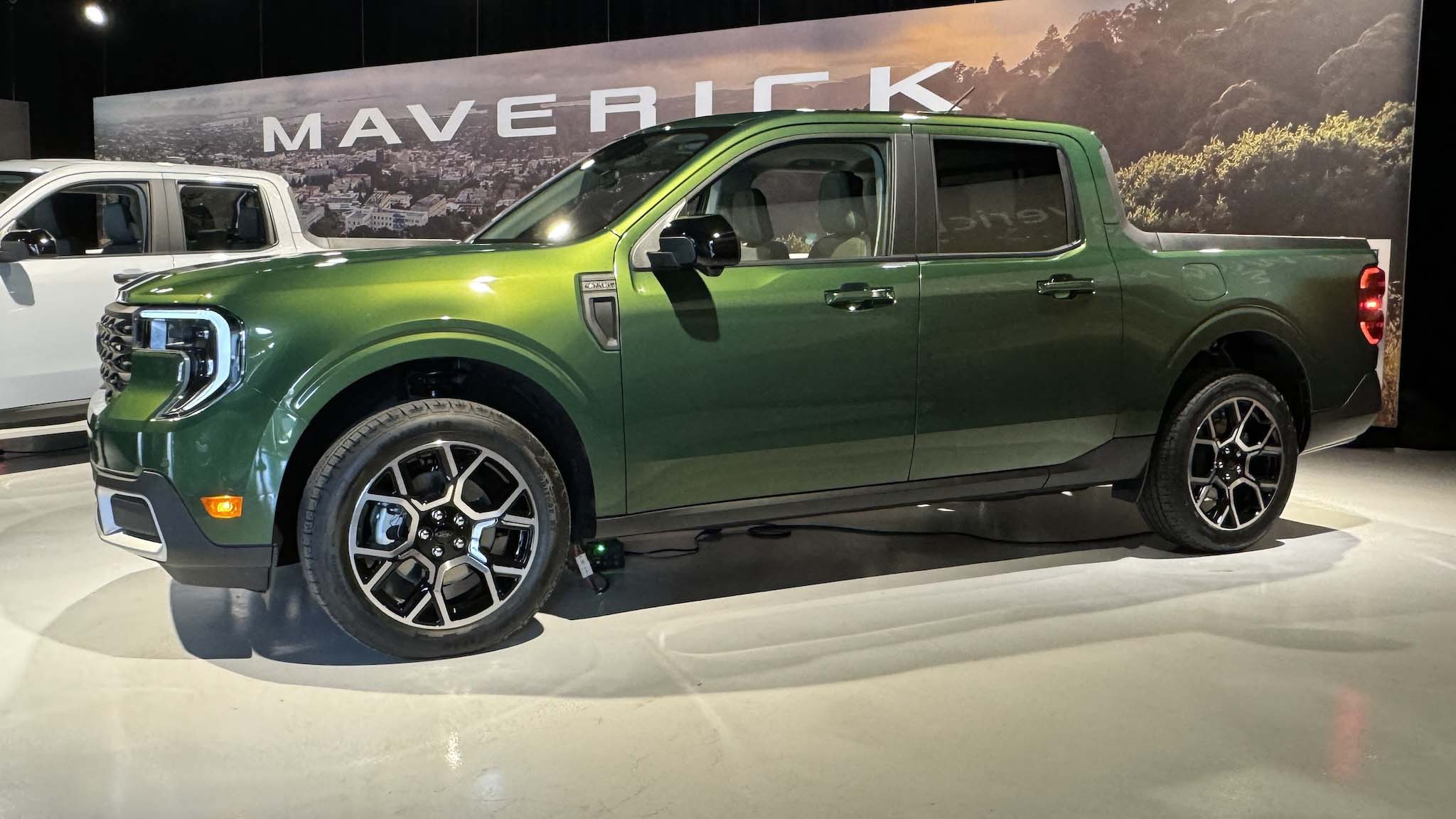 Green Ford Maverick pickup displayed at an indoor automotive exhibition