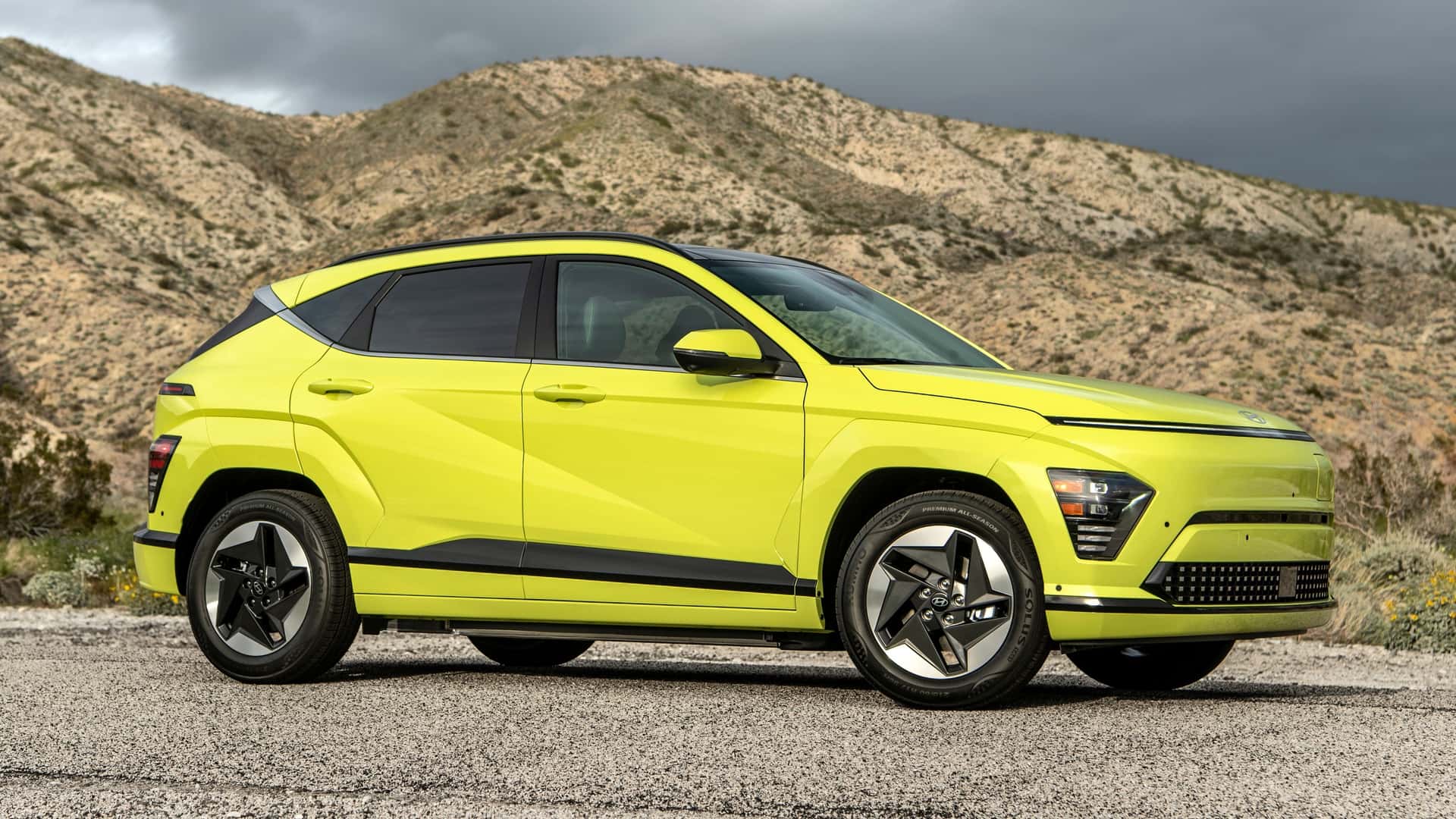 Hyundai Kona parked on a rugged mountain road with dramatic hills rising behind