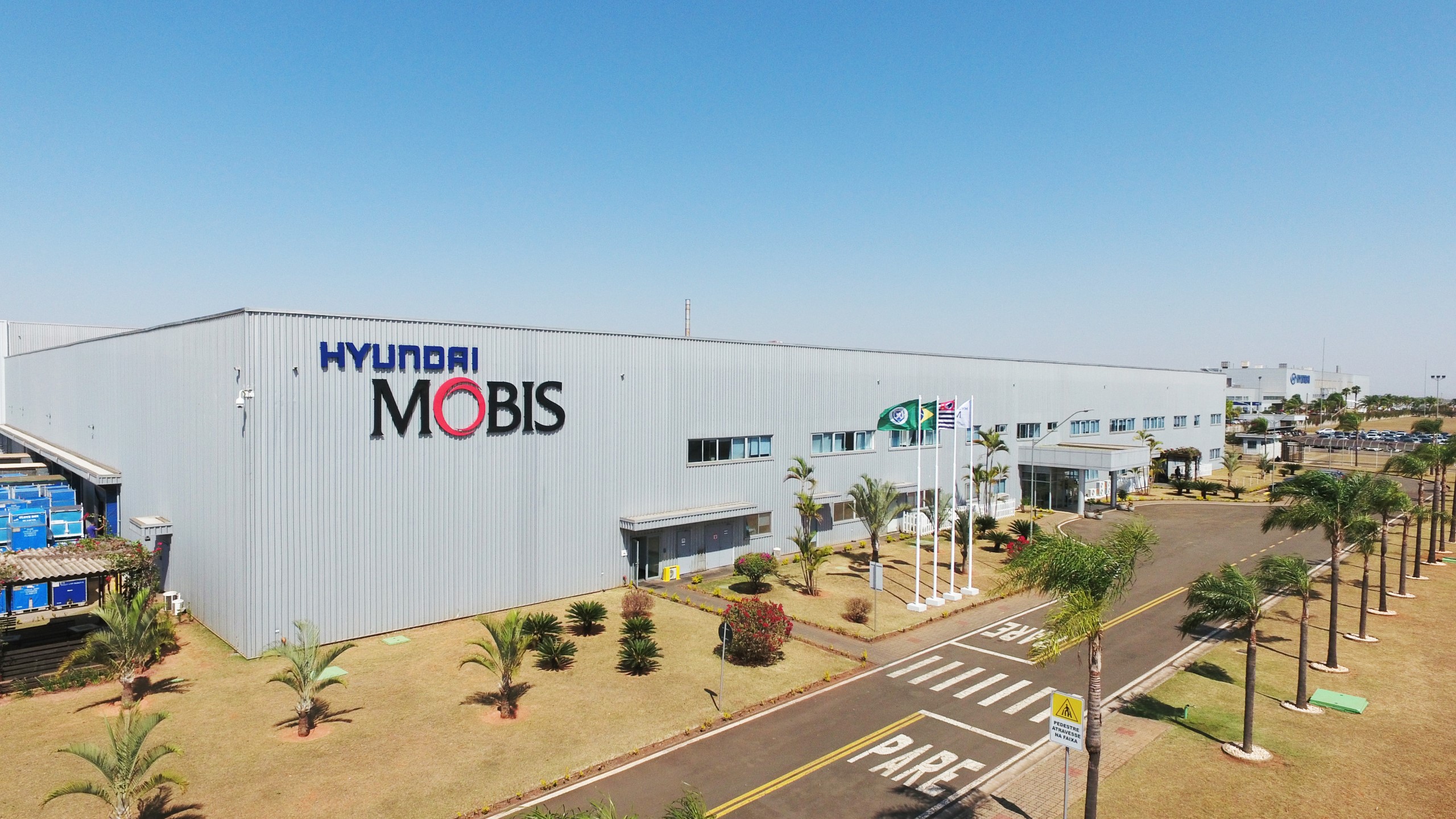 Hyundai Mobis manufacturing facility surrounded by landscaped grounds and palm-lined roads