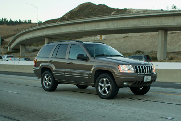 A Grand Cerokee is cruising on a flat concrete patch