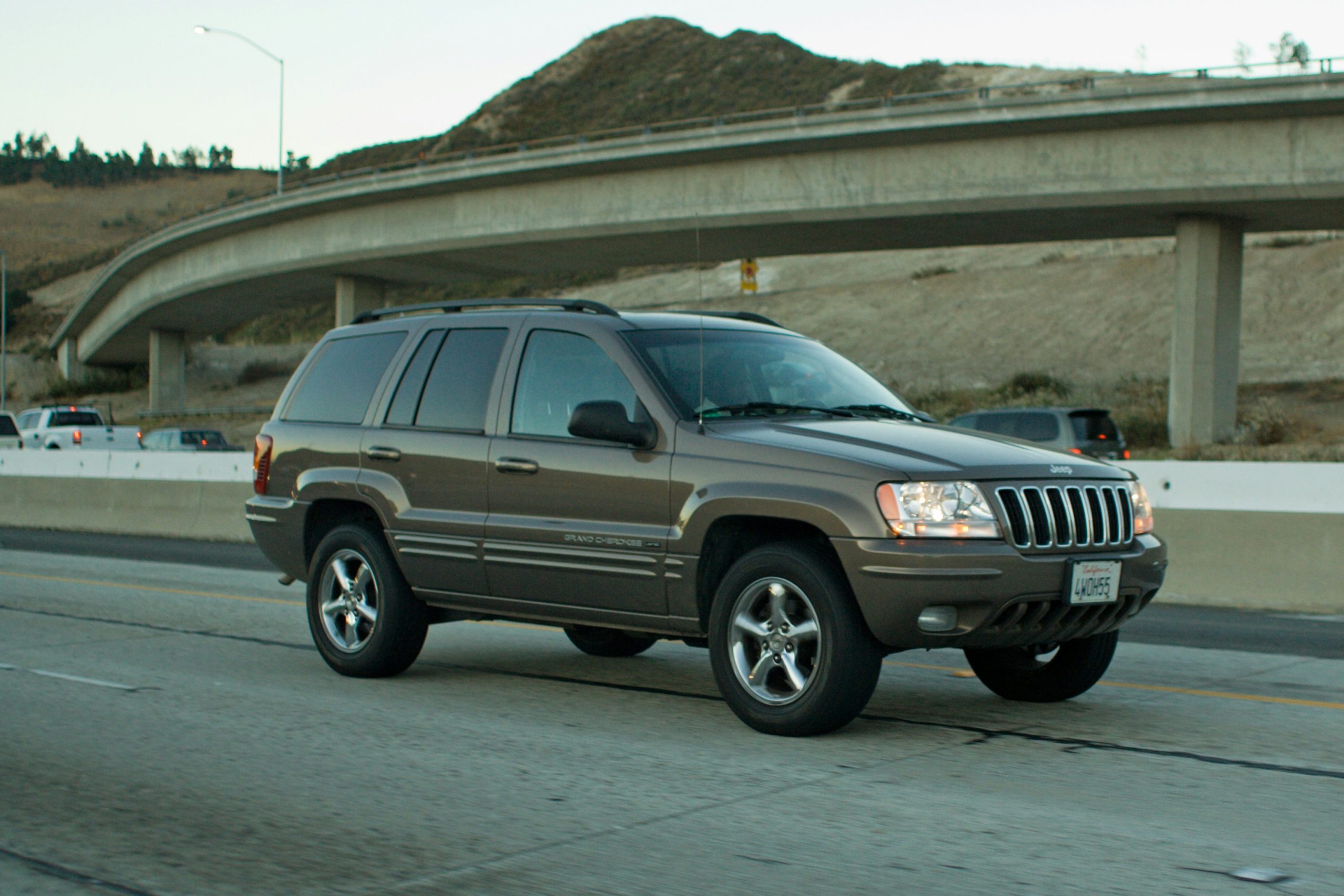 A Grand Cerokee is cruising on a flat concrete patch