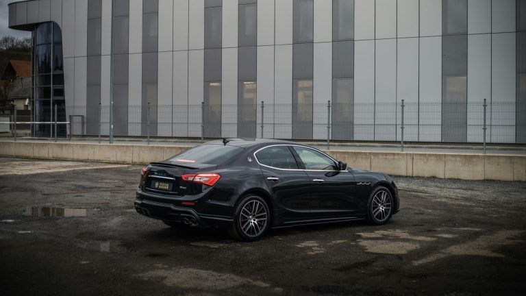 A Maserati is doing a burnout in an open parking