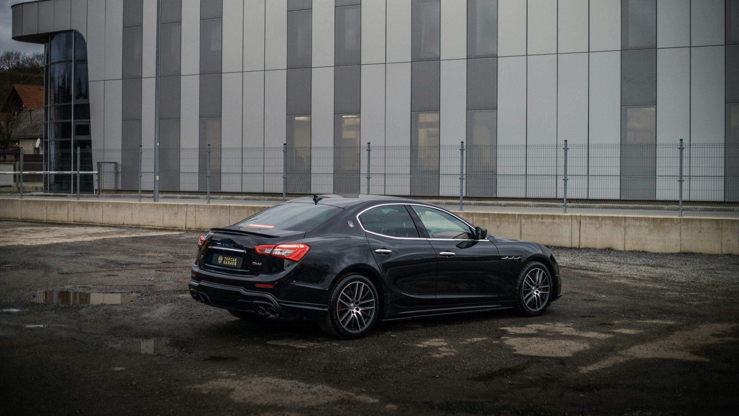 A Maserati is doing a burnout in an open parking