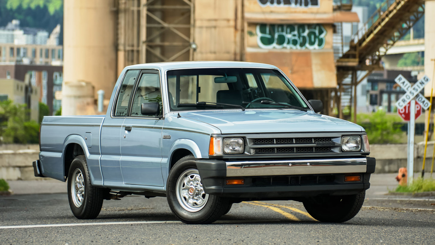 Mazda B-Series pickup parked near an industrial railway crossing, showcasing its classic compact-truck design