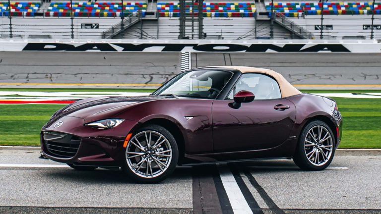 Mazda MX-5 Miata RF sports car with a tan roof, displayed at Daytona International Speedway