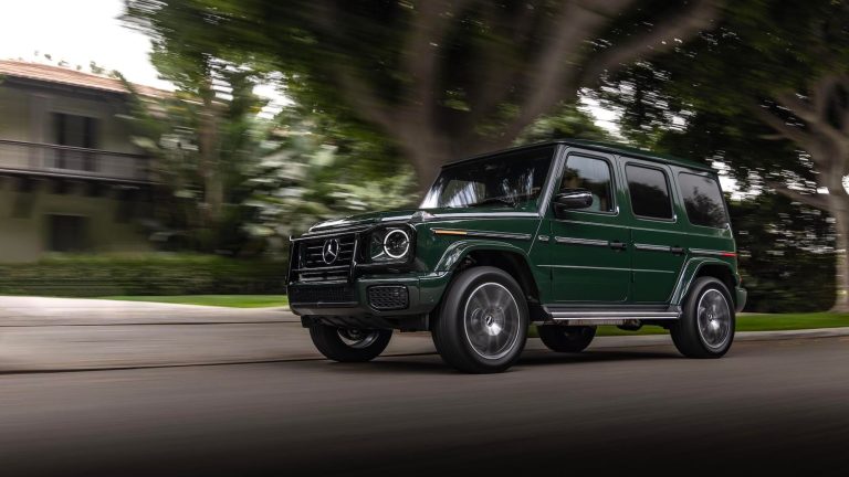 Mercedes-Benz G-Class cruises through a tree-lined neighborhood, showcasing its iconic boxy design and luxury appeal