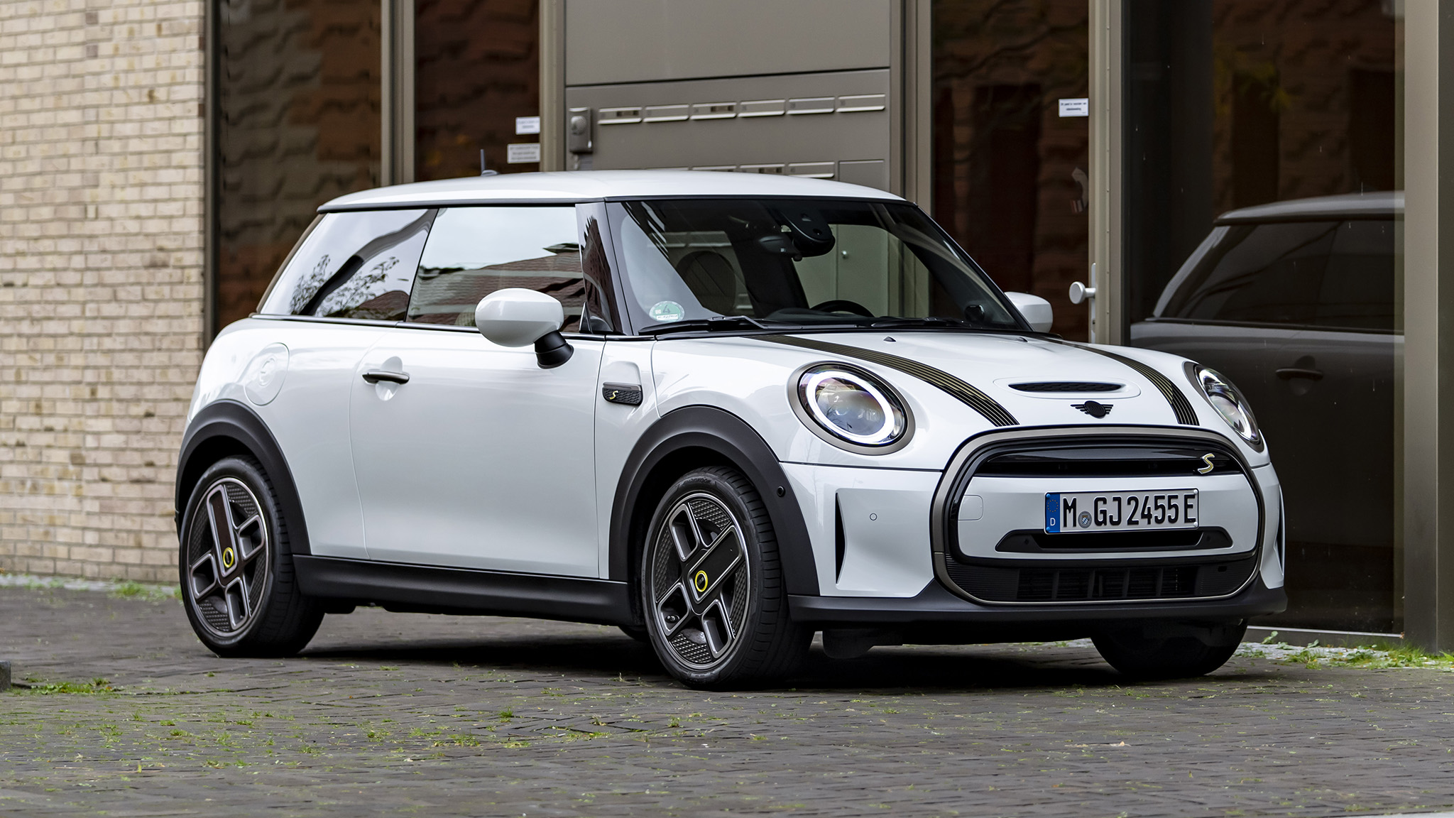 Mini Cooper SE Resolute Edition parked outside a modern building, showcasing its compact electric design