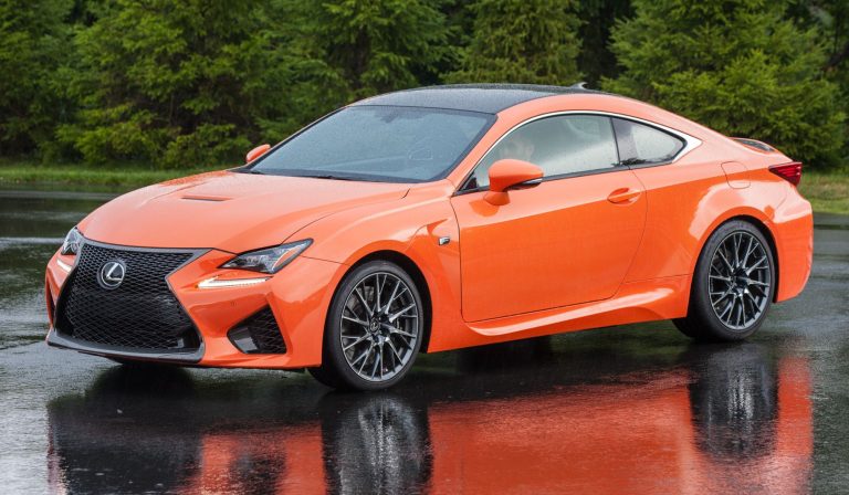 Orange Lexus RC F sports coupe parked on a wet track, showcasing its aggressive styling
