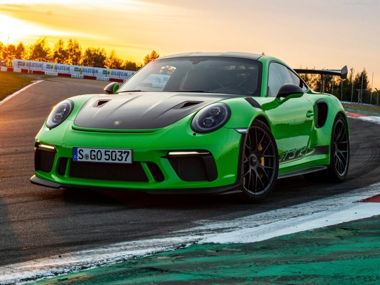 A green Porsche is cruising on a race track