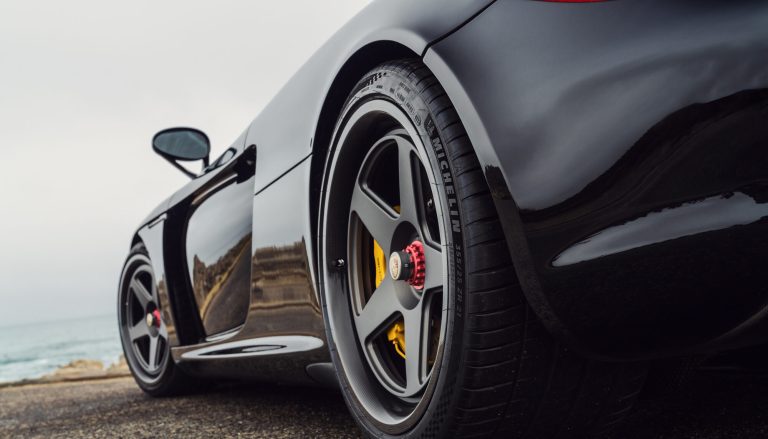 A Porsche Carrera is standning on the shore of a beach