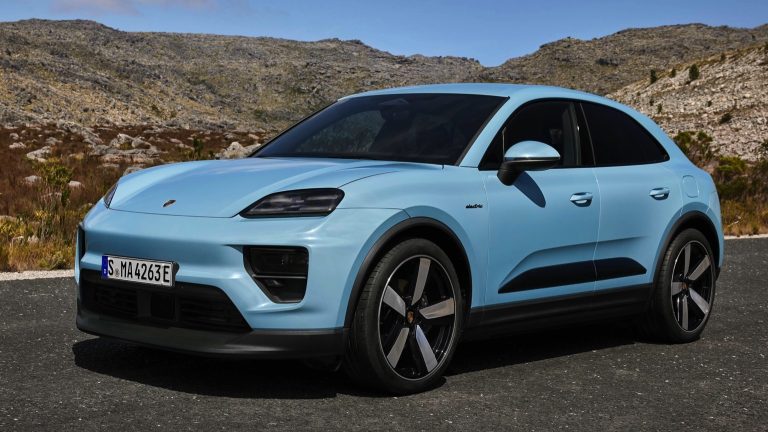 Porsche Macan Electric parked on a mountain road, showcasing its sleek design and sporty proportions
