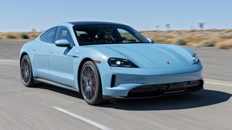 Porsche Taycan driving along an open highway, showcasing its sleek electric sports sedan design
