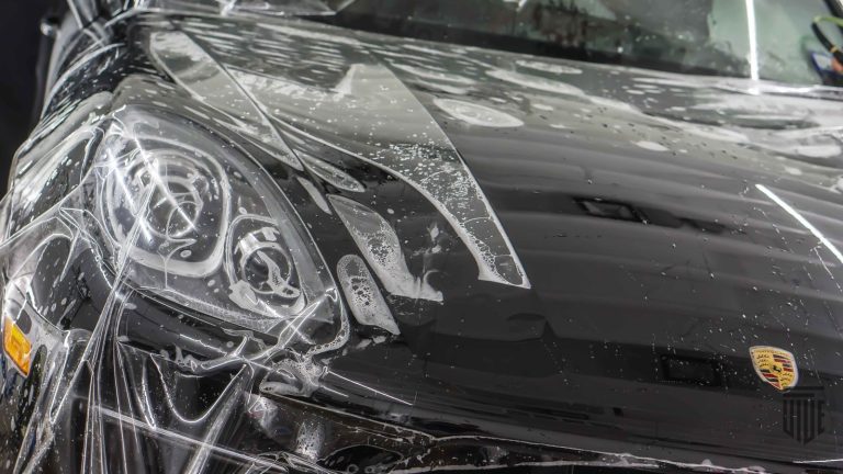 Porsche sports car covered in protective film, highlighting detailed paint protection work