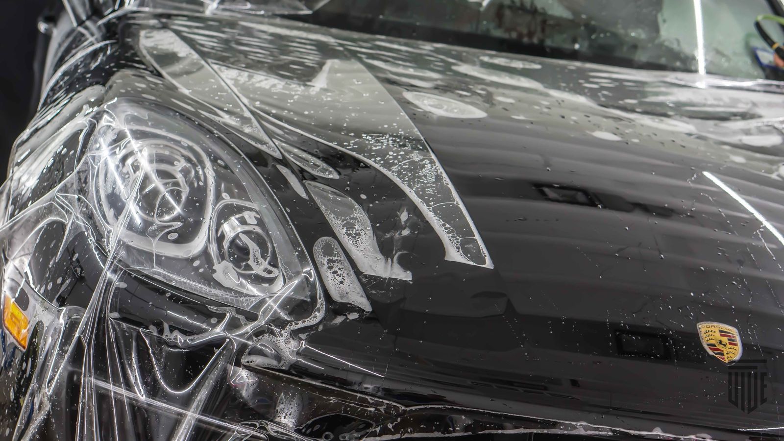 Porsche sports car covered in protective film, highlighting detailed paint protection work